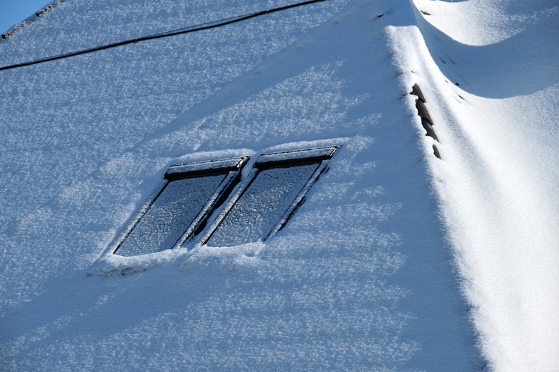 snowy covered roof with skylight