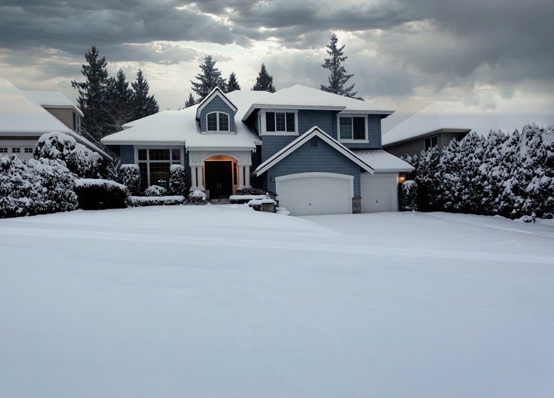 Home with snow that might cause storm damage to roof