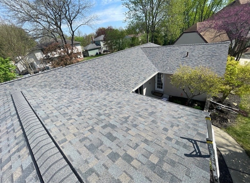 Complex gray shingle roof showing factors that affect roof replacement cost in Toledo